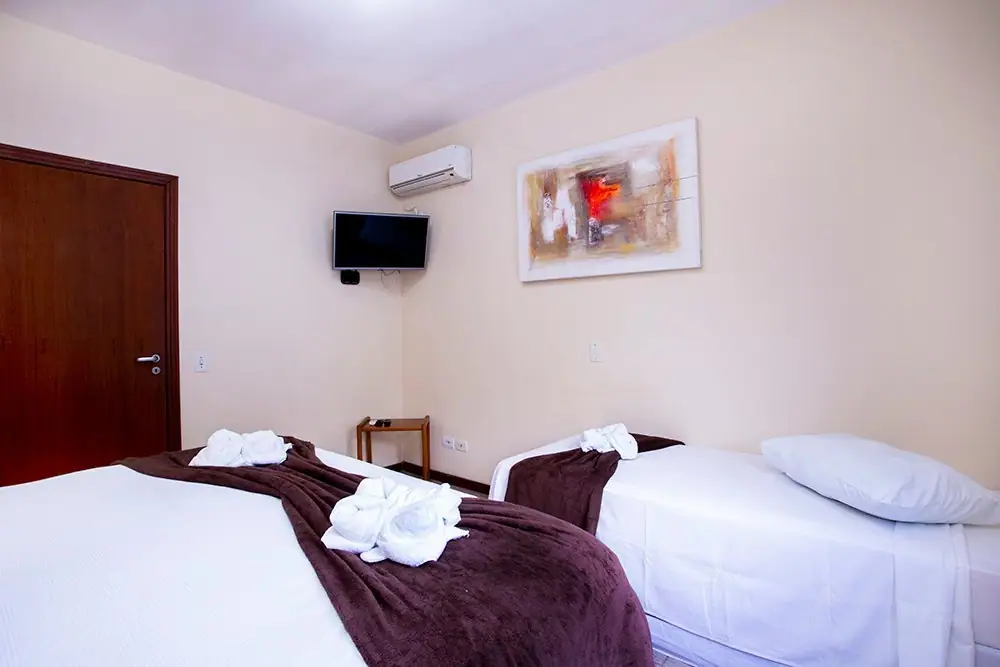 Cama queen e TV no quarto do Apartamento