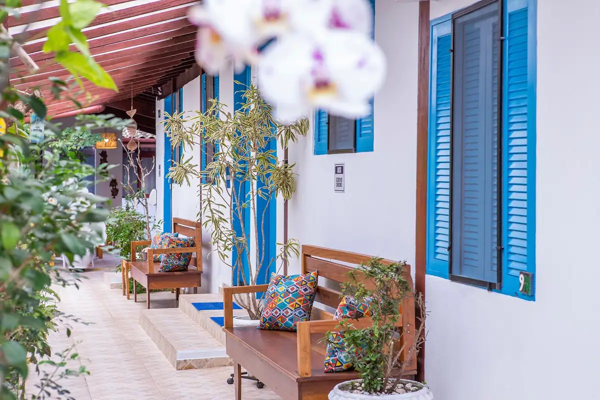 Varanda dos quartos com janelas azuis e orquídeas