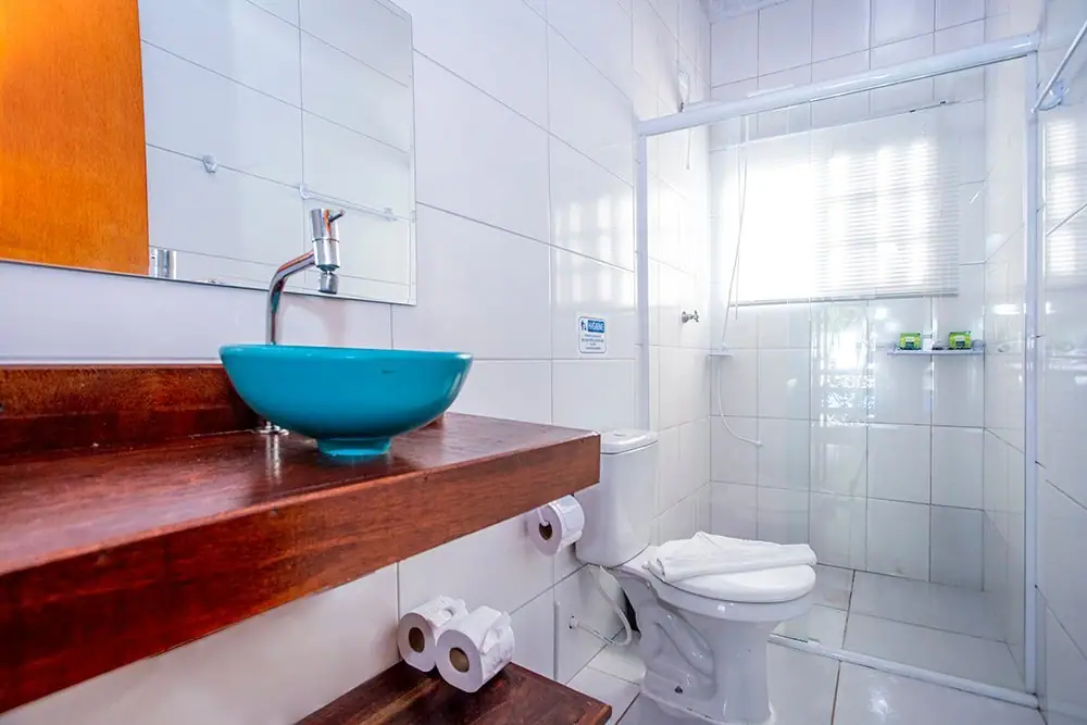 Banheiro da Suíte Deluxe com pia de cuba azul e box