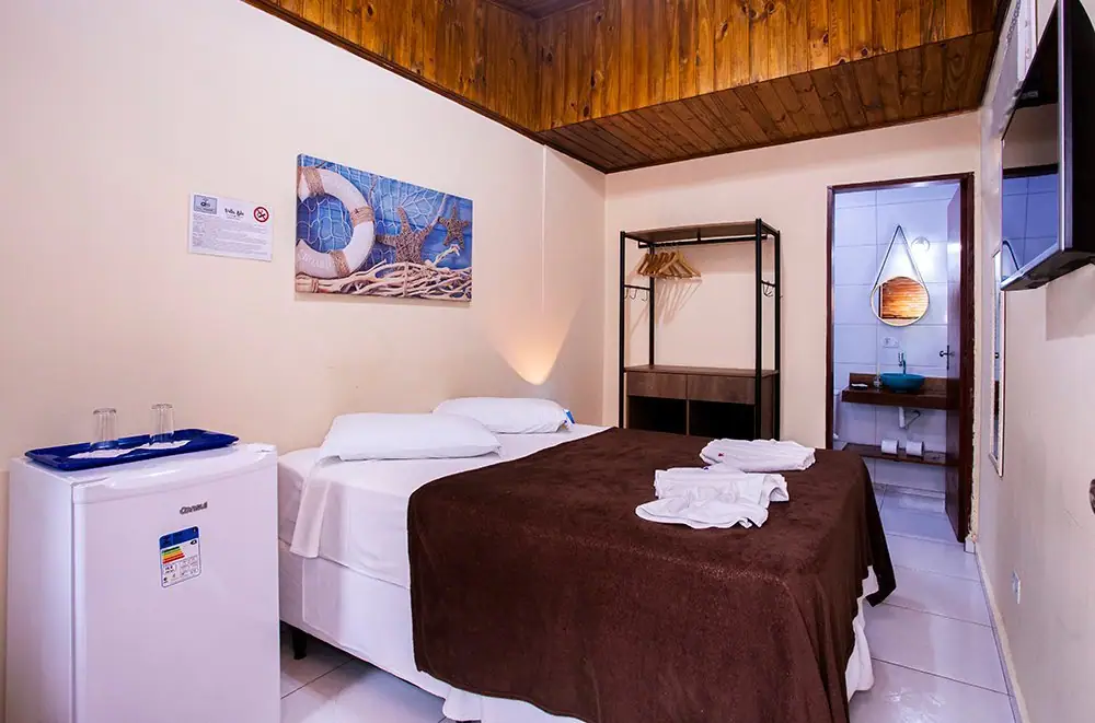 Suíte Econômica da Pousada Villa Blu, em Maresias, com cama de casal, frigobar e TV