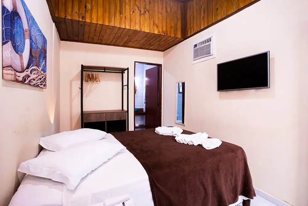 Cama de casal da Suíte Econômica com ar-condicionado e TV