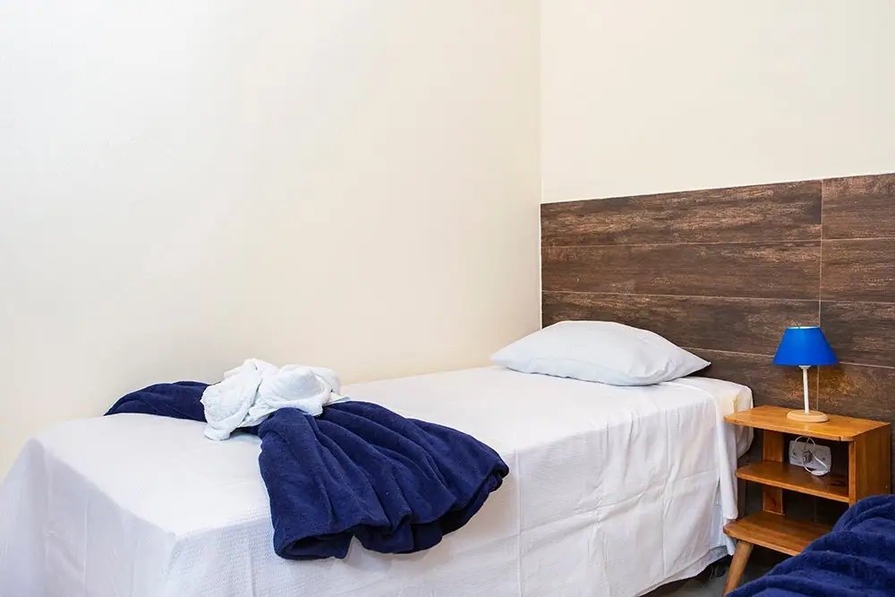 Cama de solteiro da Suíte Standard com abajur azul